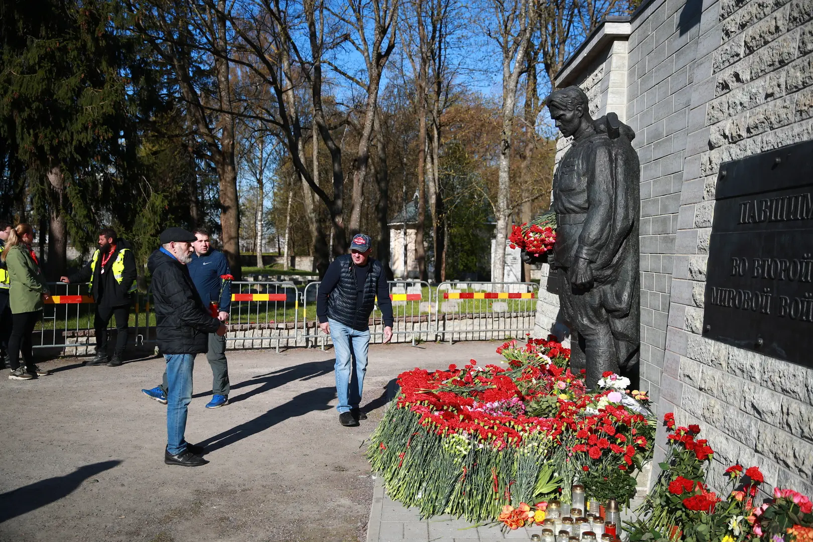 Жители Таллинна несут цветы к Бронзовому солдату
